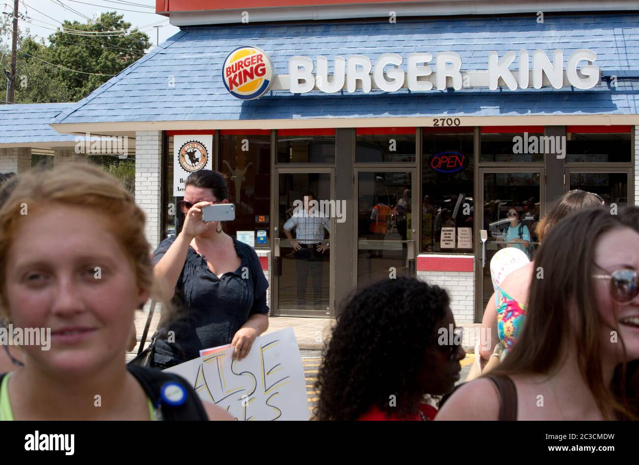 August 29, 2013 Austin, Texas USA: Customer watches from behind restaurant door as fast-food workers and sympathizers march past a Burger King to protest low wages. ©Marjorie Kamys Cotera/Daemmrich Photography Stock Photo