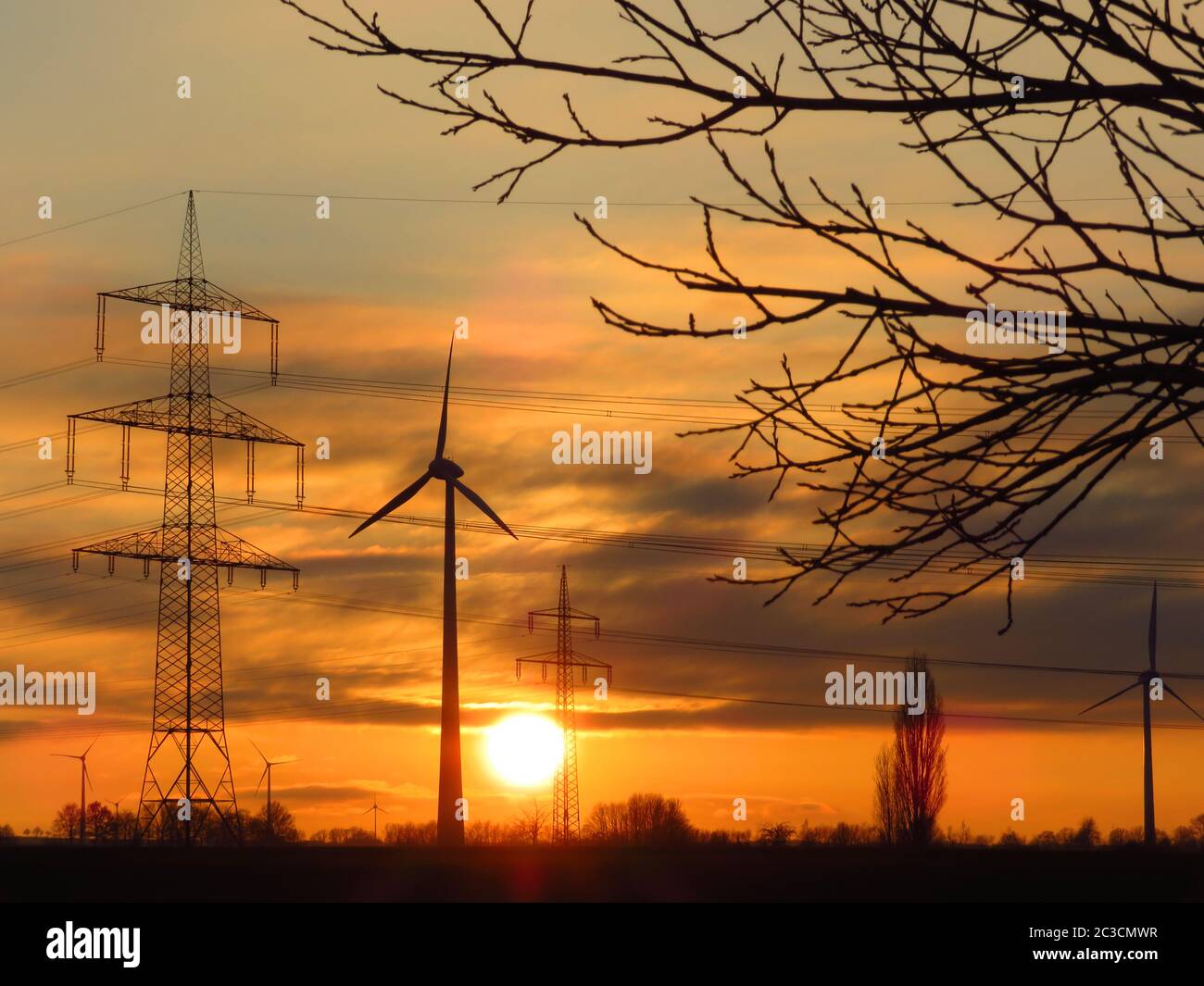 Energy types sun, windmill, electricity, transmission tower in sunset