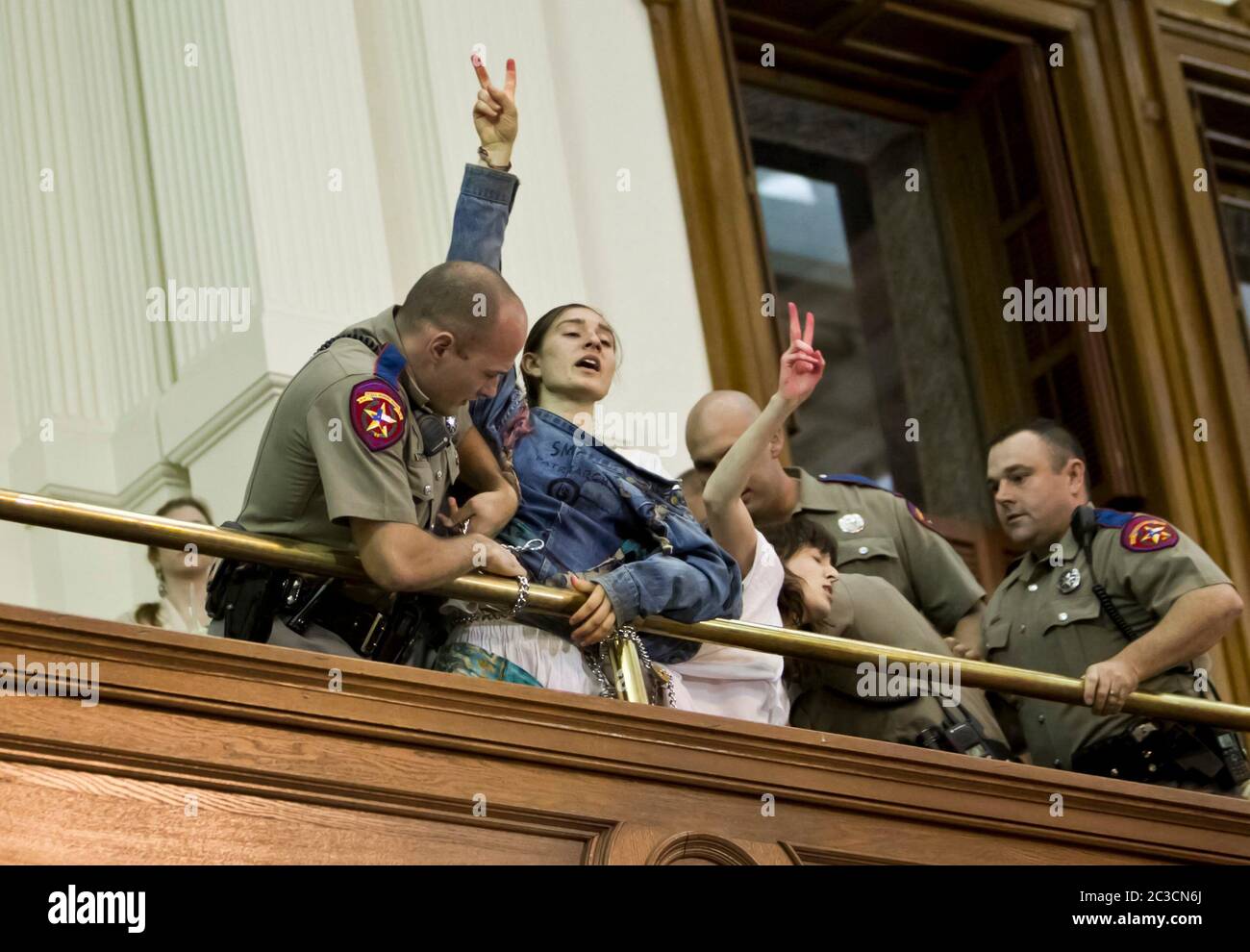 July 11, 2013, Austin, Texas USA: Texas Department of Public Safety officers remove two young women from the gallery of the Texas Senate as they shouted their opposition to proposed controversial legislation restricting access to abortion.  ©Marjorie Kamys Cotera/Daemmrich Photography Stock Photo