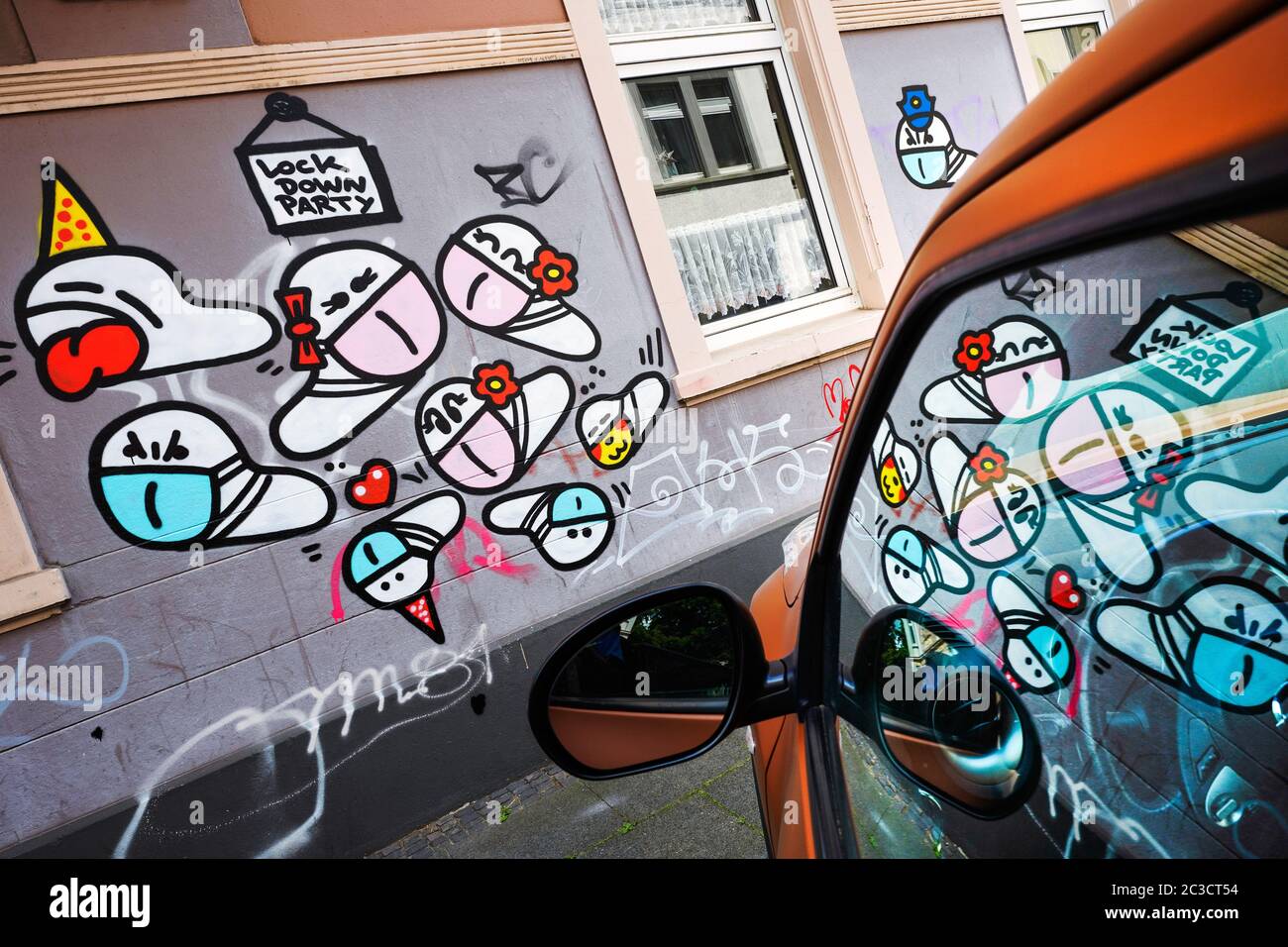 Dortmund, Germany, June 19th, 2020: Mask worms. Since the outbreak of the corona crisis in March 2020, small corona virus graffiti with a mouth mask created by an unknown sprayer can be seen on many house walls in Dortmund. --- Dortmund, 19.06.2020: Maskenwürmchen. Seit Ausbruch der Corona-Krise im März 2020 sind kleine Coronaviren-Graffitis mit Mundschutz eines unbekannten Sprayers an vielen Hauswänden in Dortmund zu sehen. Stock Photo