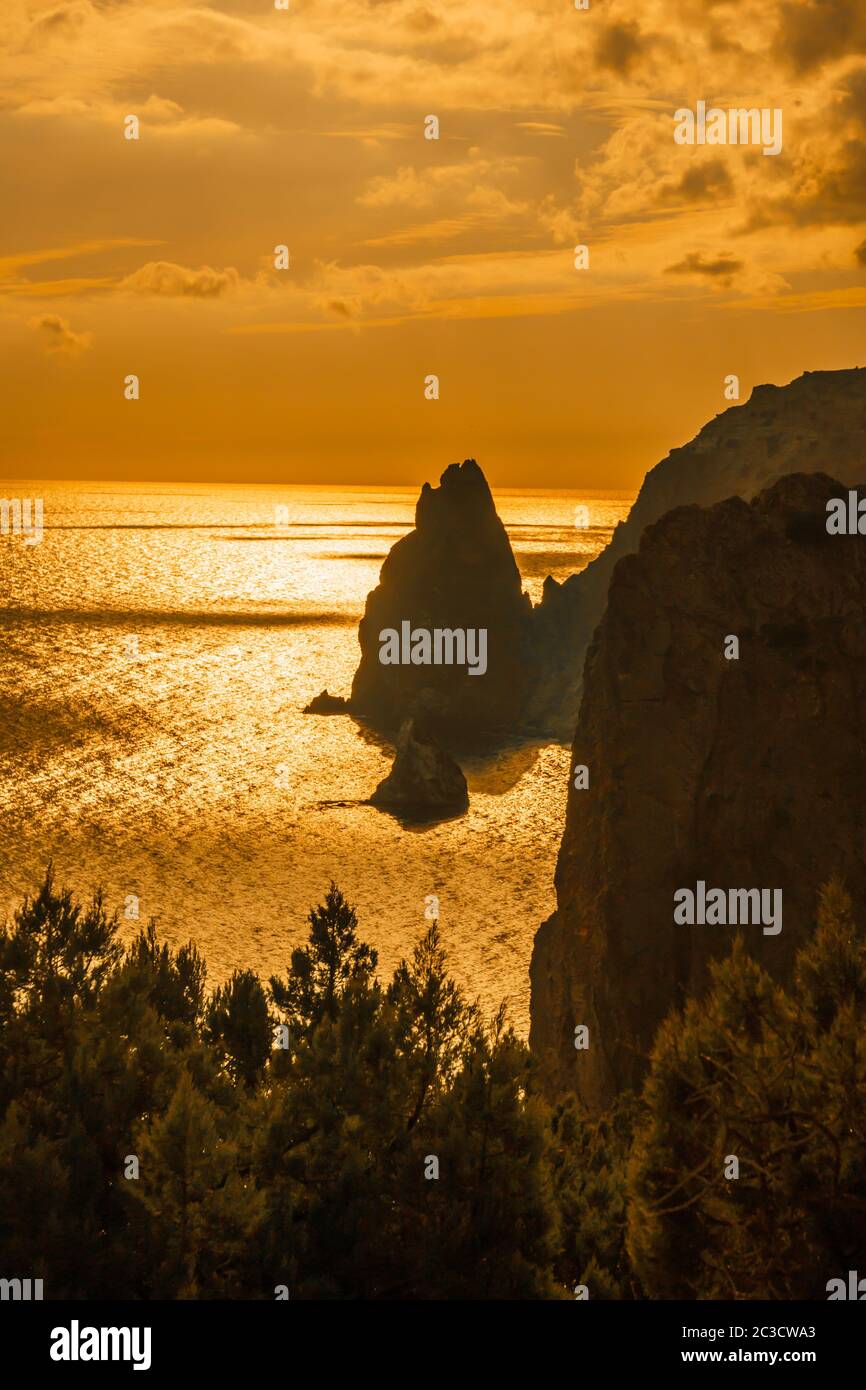 A red burning sunset with the silhouett of cape Fiolent and cliff over ...