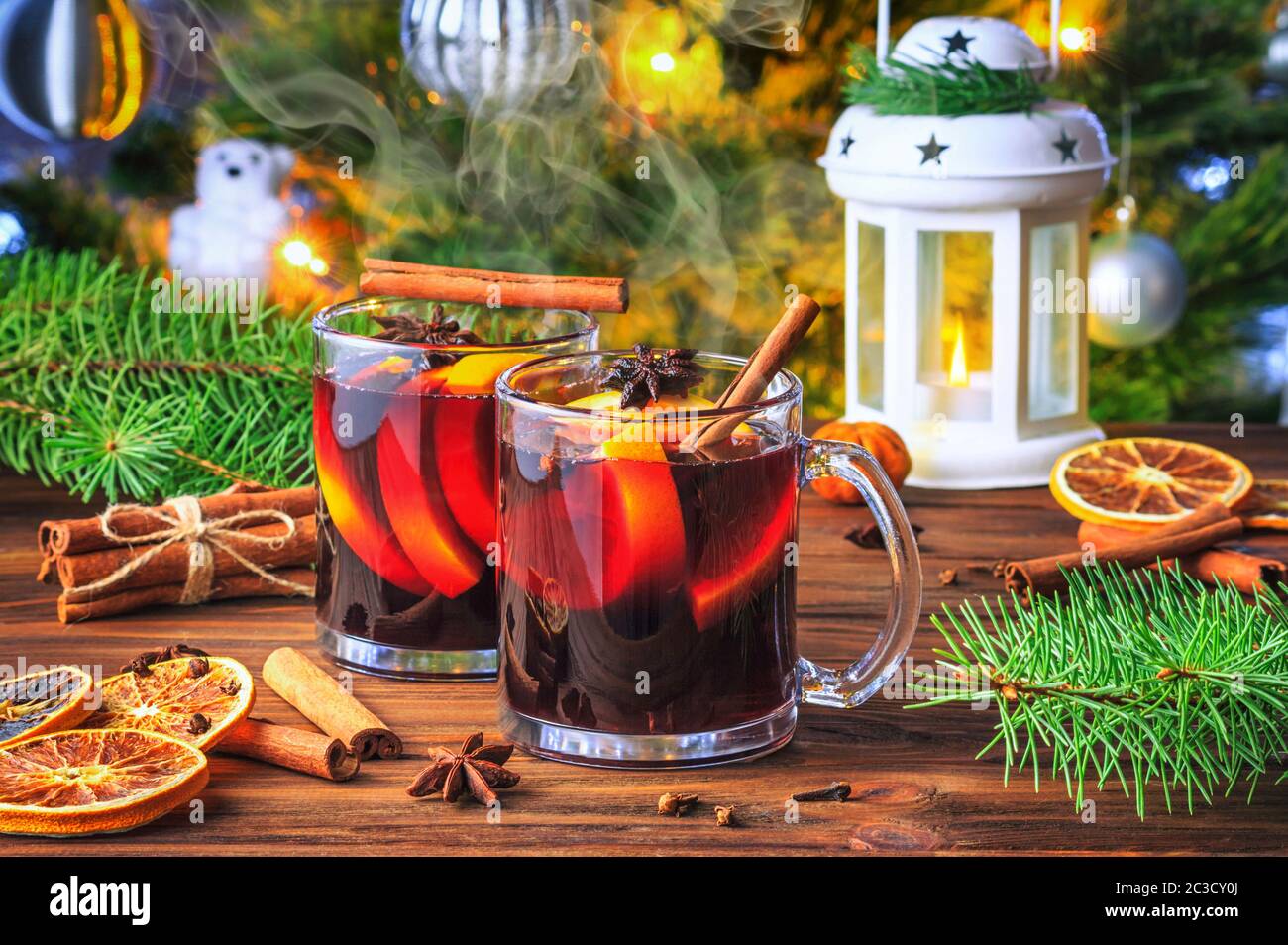 Christmas mulled red wine glühwine with aromatic spices and citrus fruits on a wooden rustic table, close-up. Traditional hot drink or festive cocktai Stock Photo