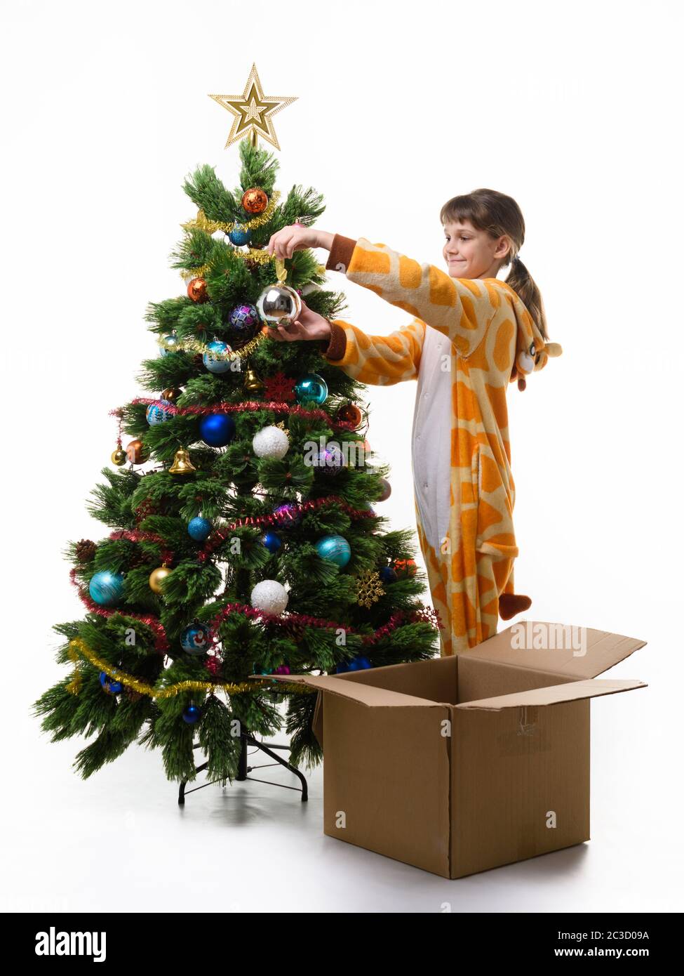 Nine-year-old girl with a smile dresses up The Christmas tree Stock Photo