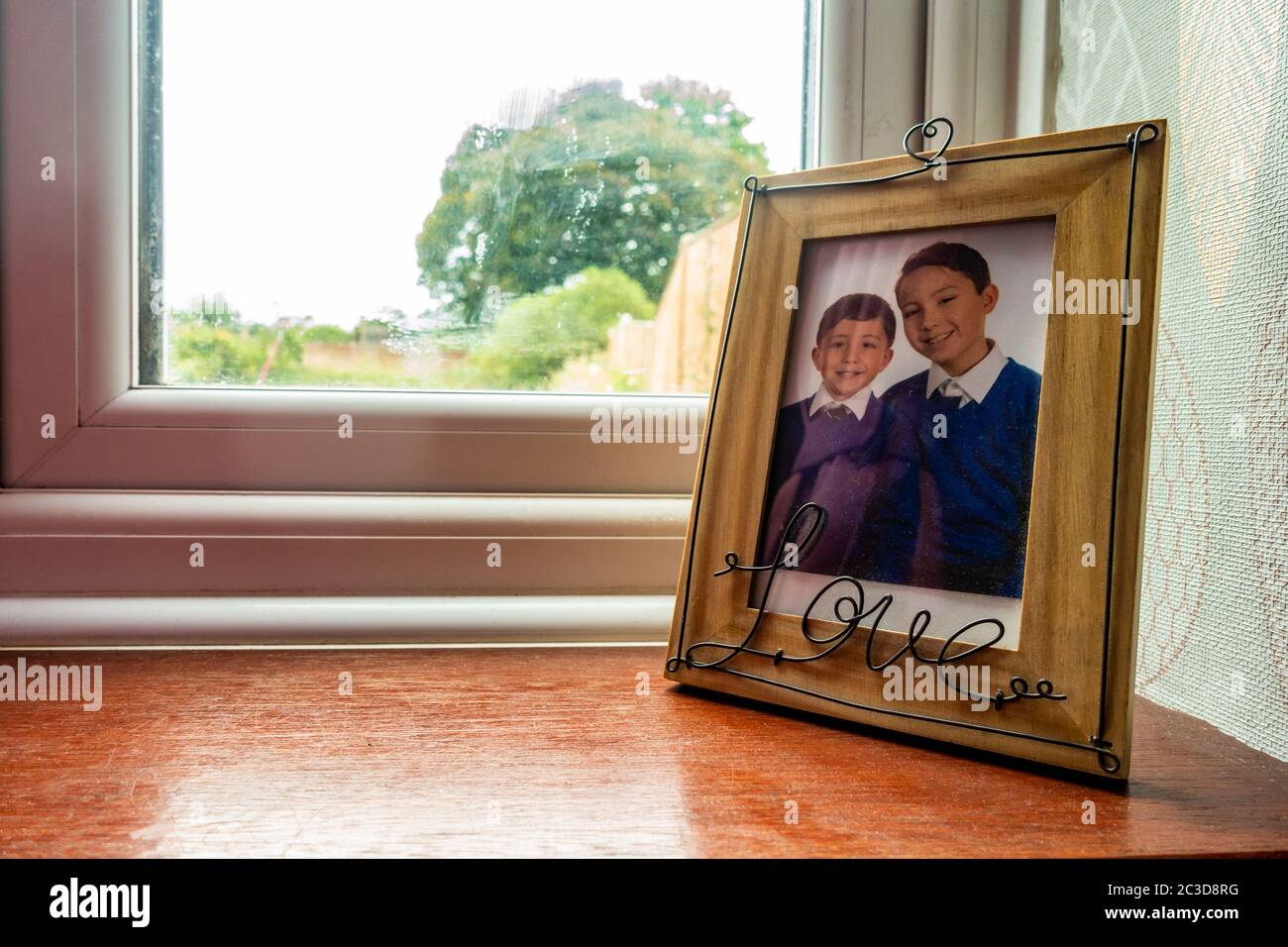 A school photo of young brothers in a picture frame on a widow sill. Stock Photo