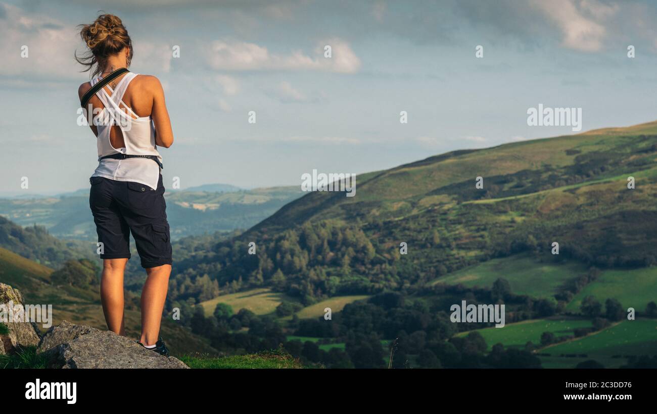 Female Traveler on the top of the mountain. Hiking. Landscape panorama, Pistyll Rhaeadr, Y Berwyn National Nature Reserve, Wales, United Kingdom, Euro Stock Photo