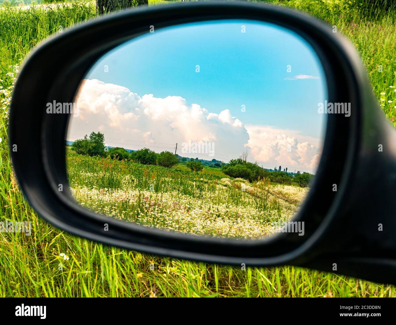 Cloudy blue sky landscape in a car rearview mirror Stock Photo Alamy