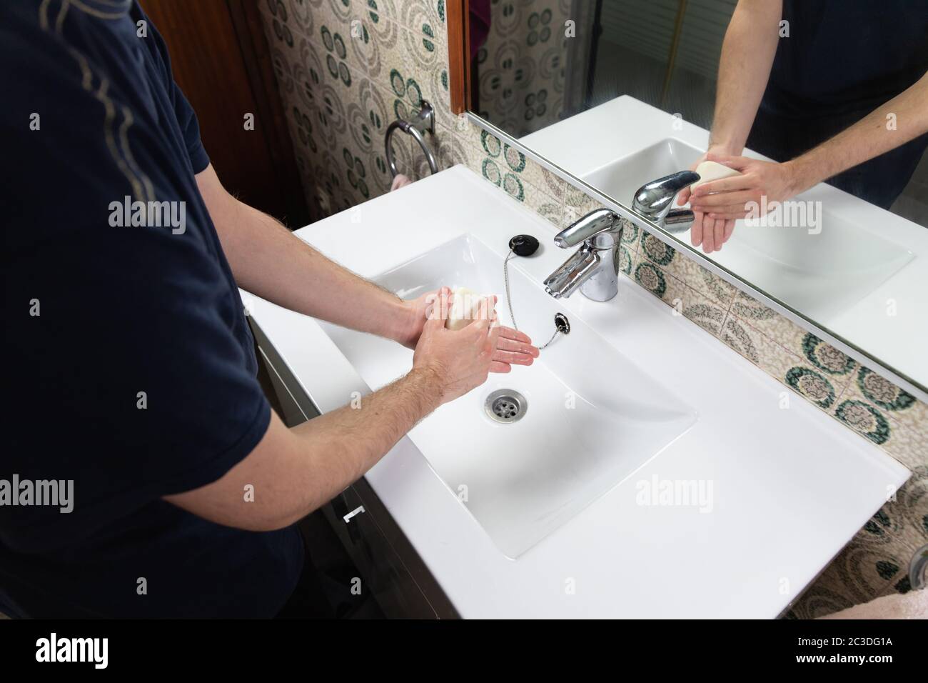 Man washing his hands with soap bar in his home. Plastic free alternative to gel soap. Zero
