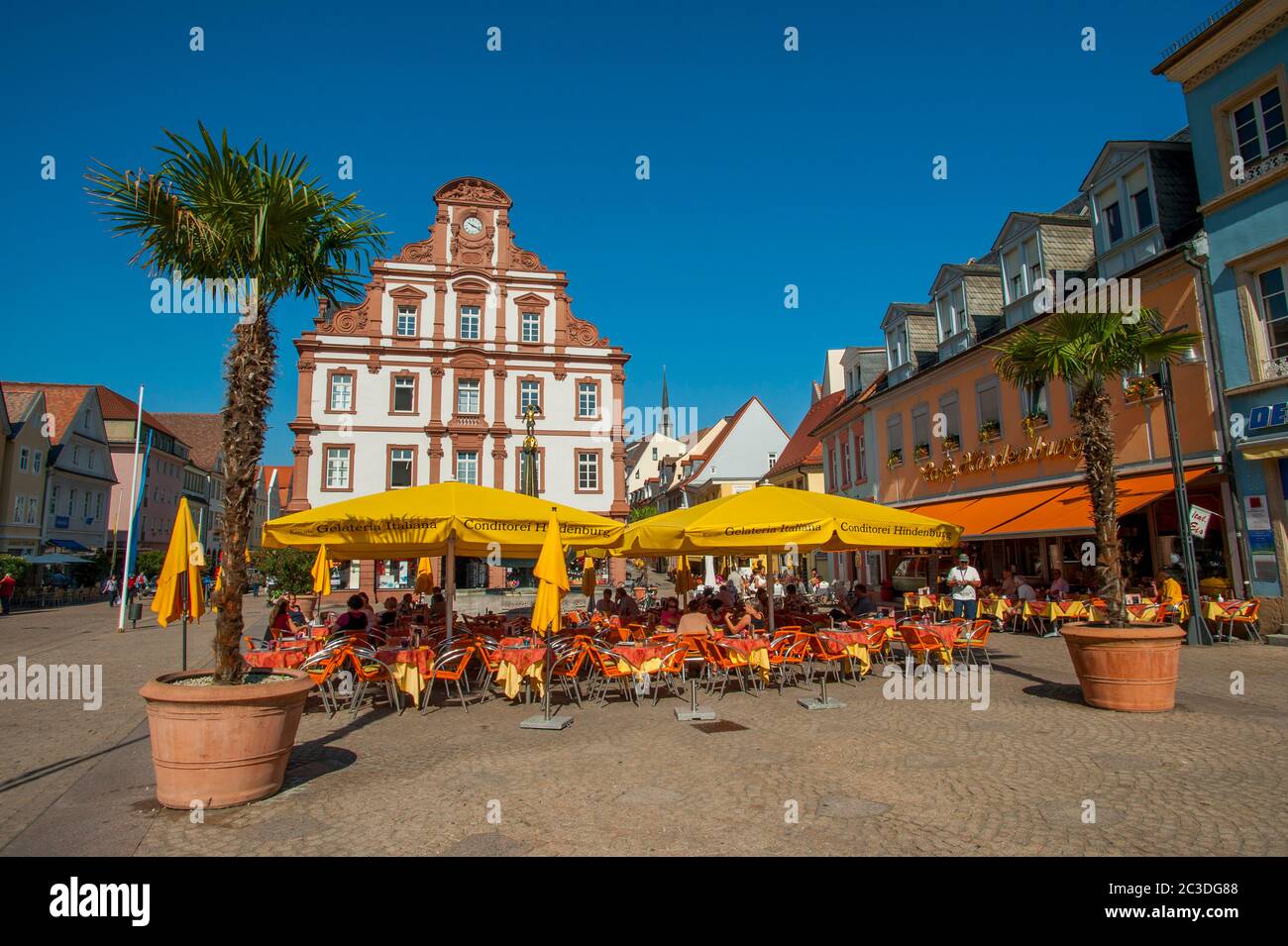 The market place with sidewalk restaurants and the old Mint on the Maximilian Street in Speyer, a town on the Rhine River in Germany. Stock Photo