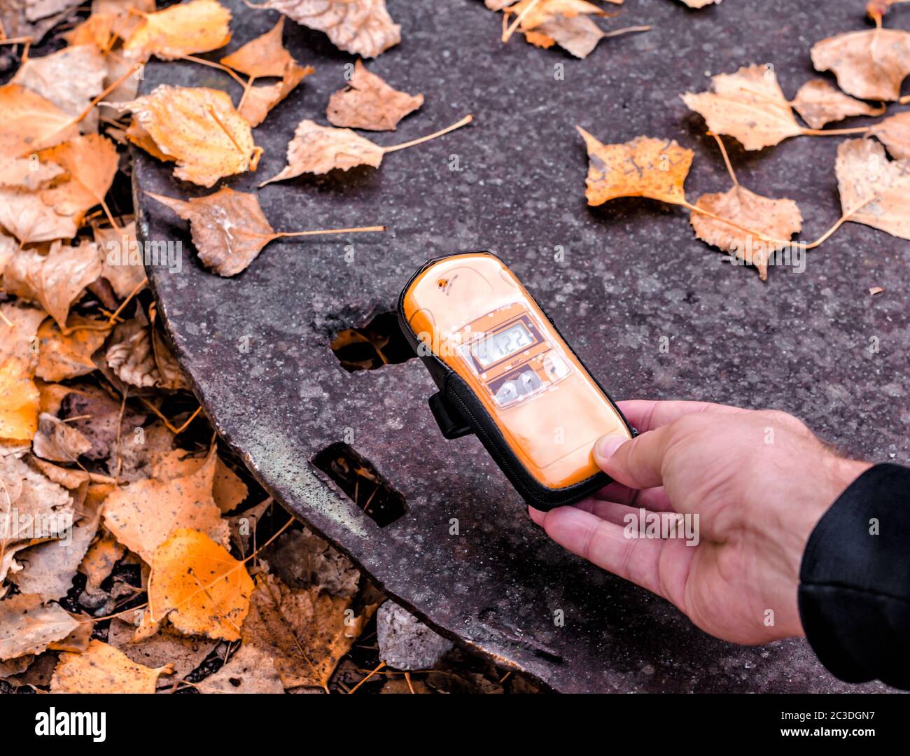 dosimeter device in a male hand near an infected radioactive object in
