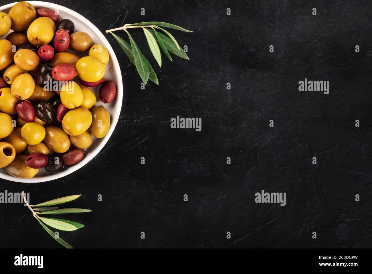 Olives assortment design template. Black, green and red olives, shot from the top on a black background with a place for text Stock Photo