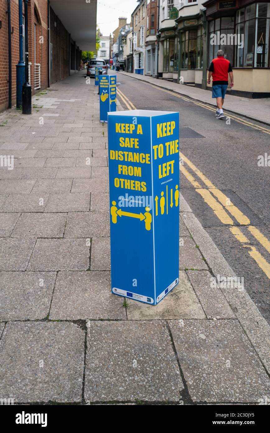 Ramsgate, UK - June 19 2020 A social distancing reminder sign plus a request to keep left on street with double yellow lines.  A local man is walking Stock Photo