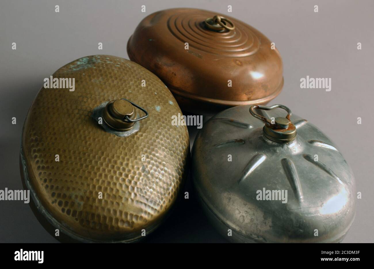 Set of antique metal hot water bottles in zinc, copper, brass Stock