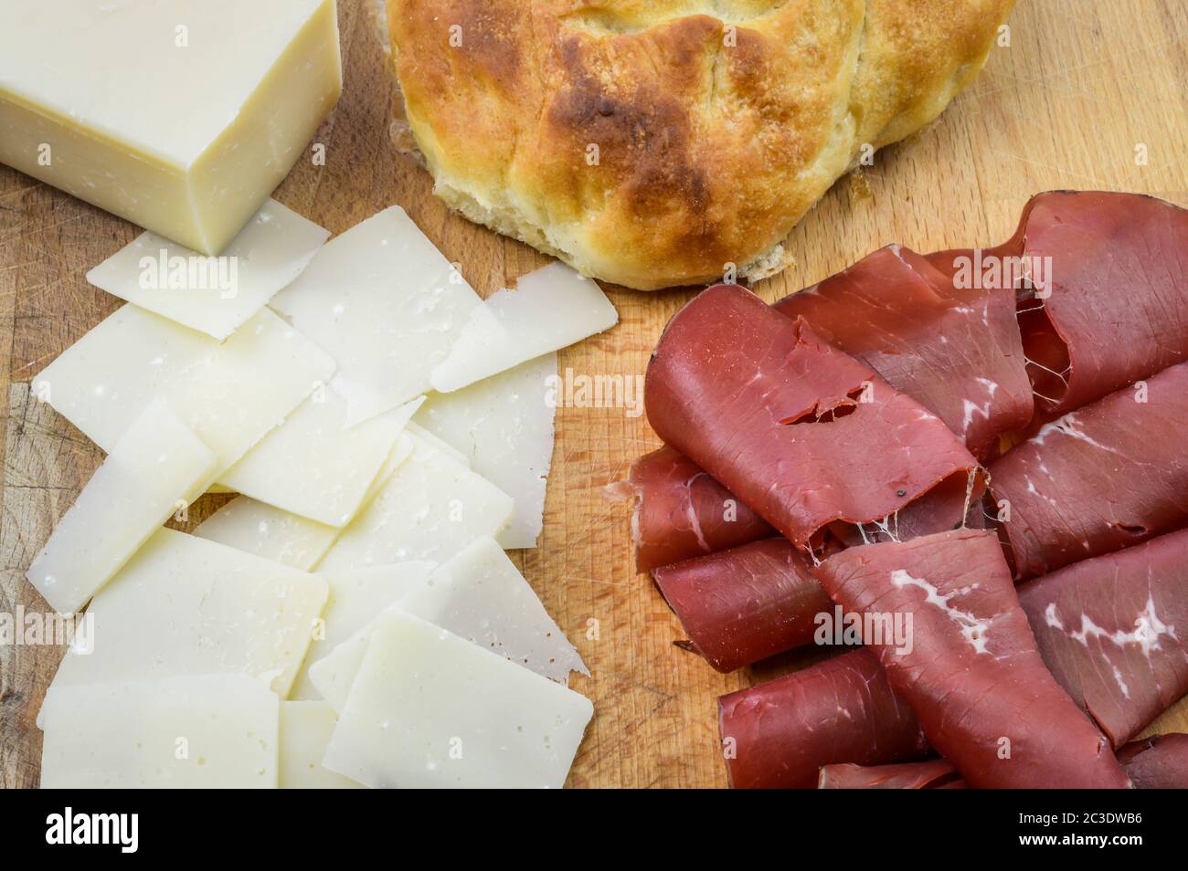 Charcuterie board with italian bresaola cured beef, grana padano cheese flakes and focaccia