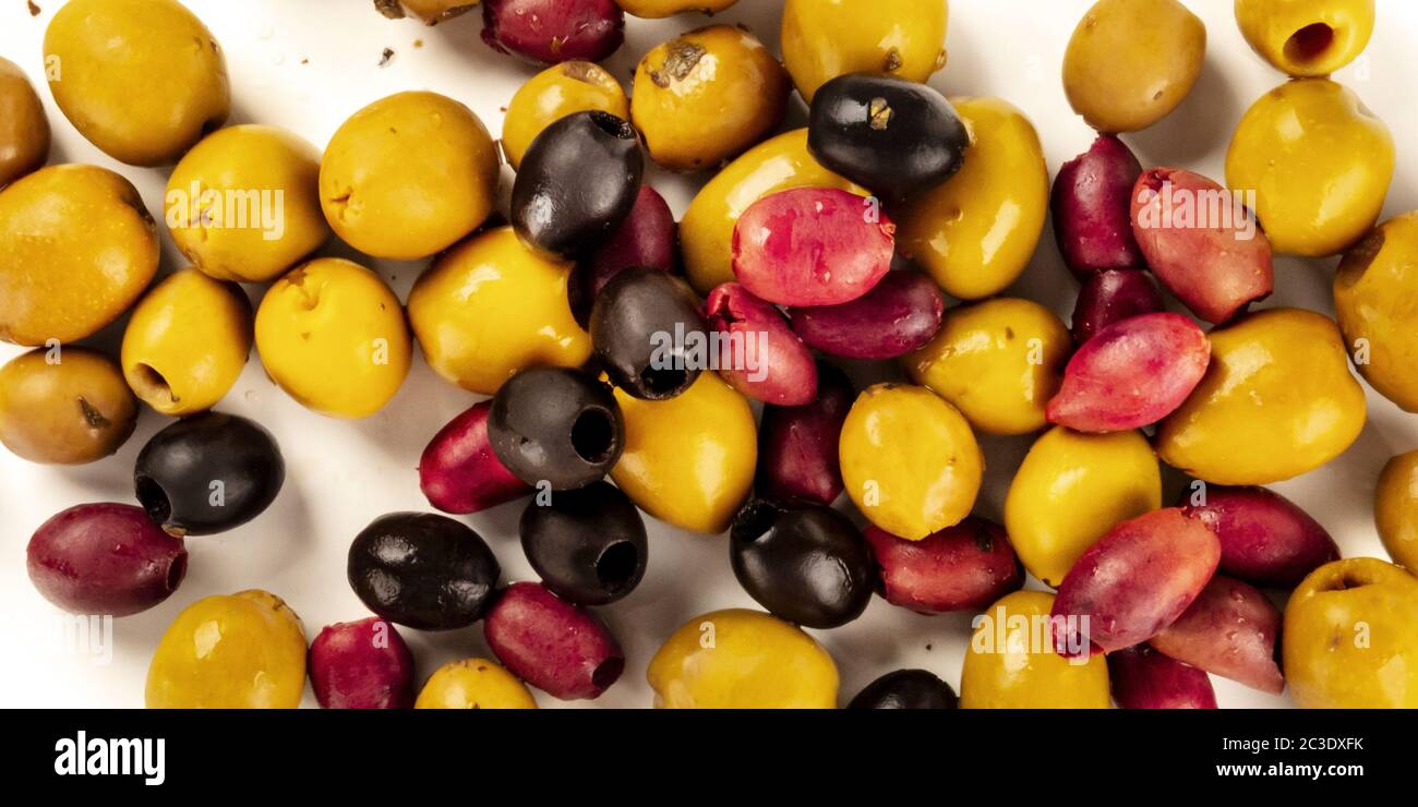Olives panorama. An assortment of green, black and red olives, shot from the top on a white background Stock Photo
