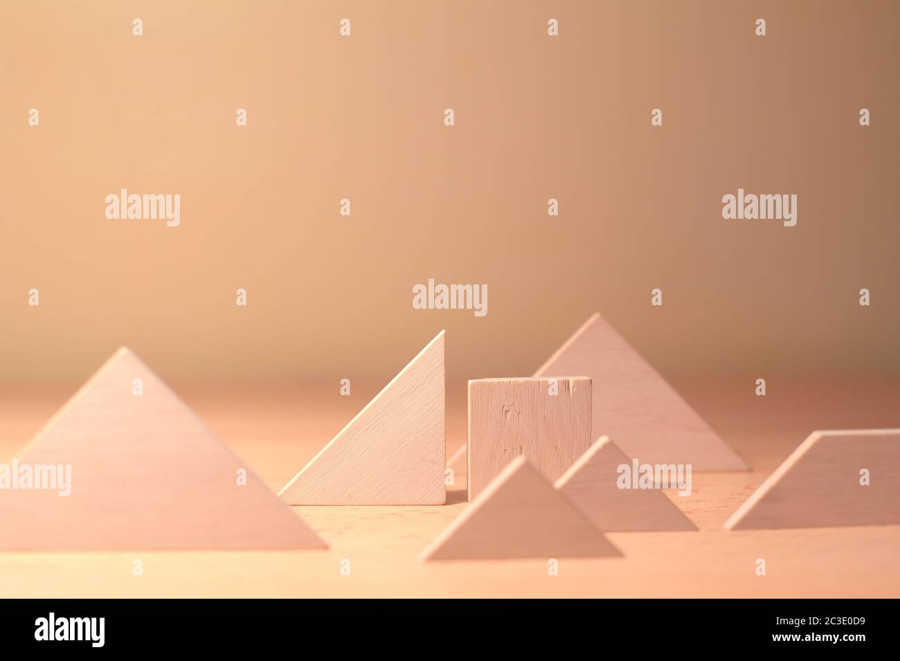 Composition of various geometrical objects - square, triangle - on wooden desk. Shallow focus, cream tint. Stock Photo