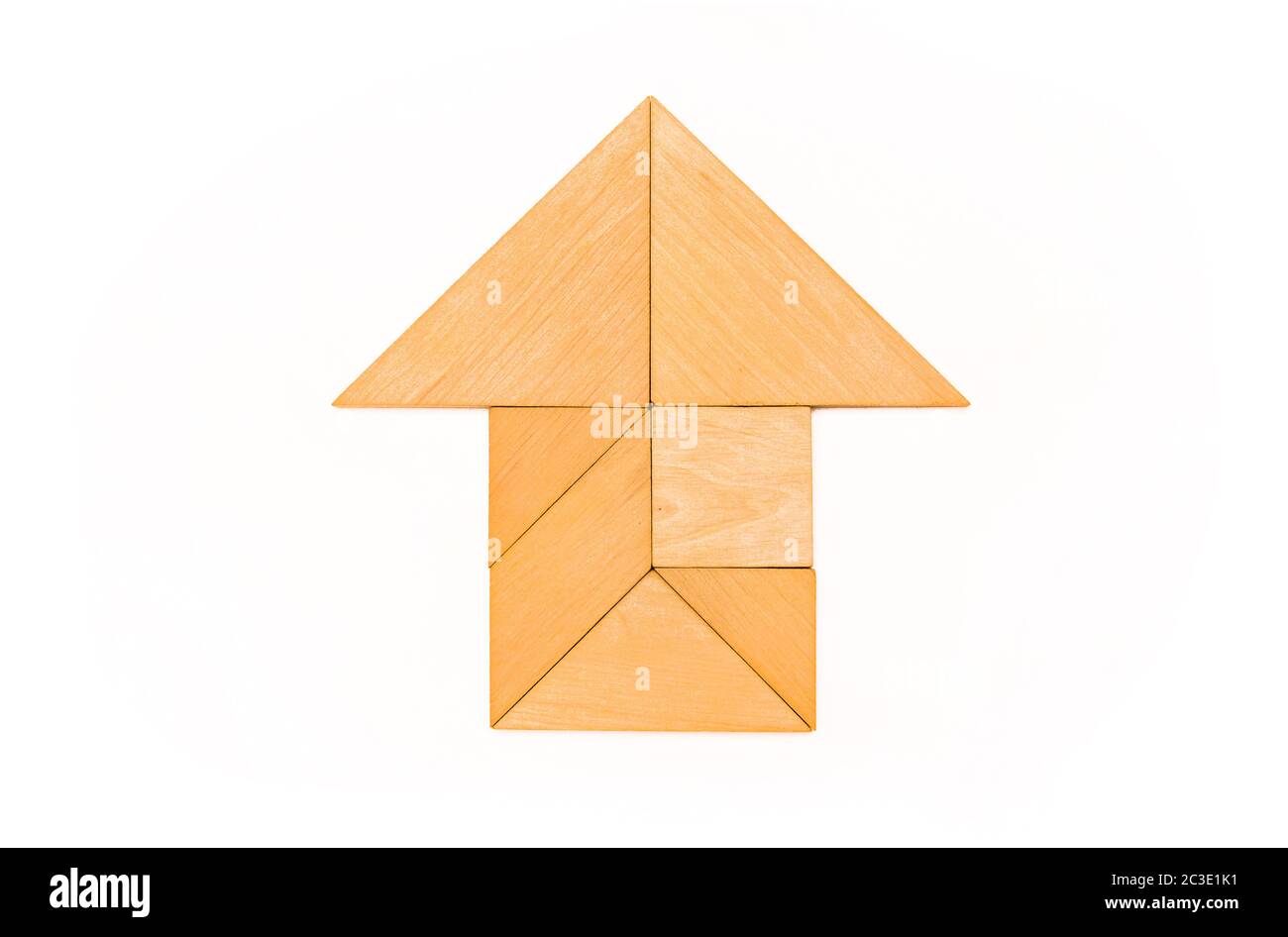 Flat lay - pictogram, symbol and icon of house and arrow made of wooden tangram pieces. White background. Stock Photo