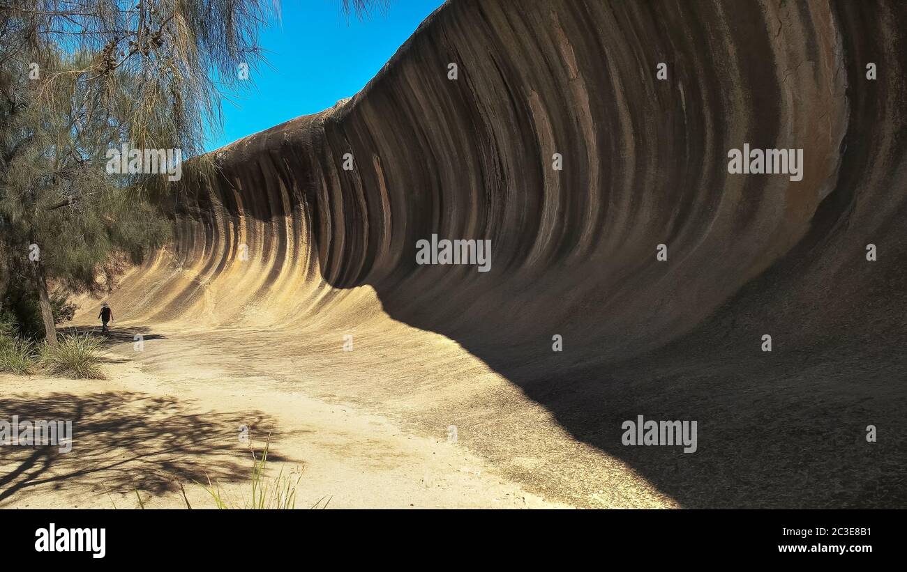 a tourist walks past the rock formation known as wave rock Stock Photo ...