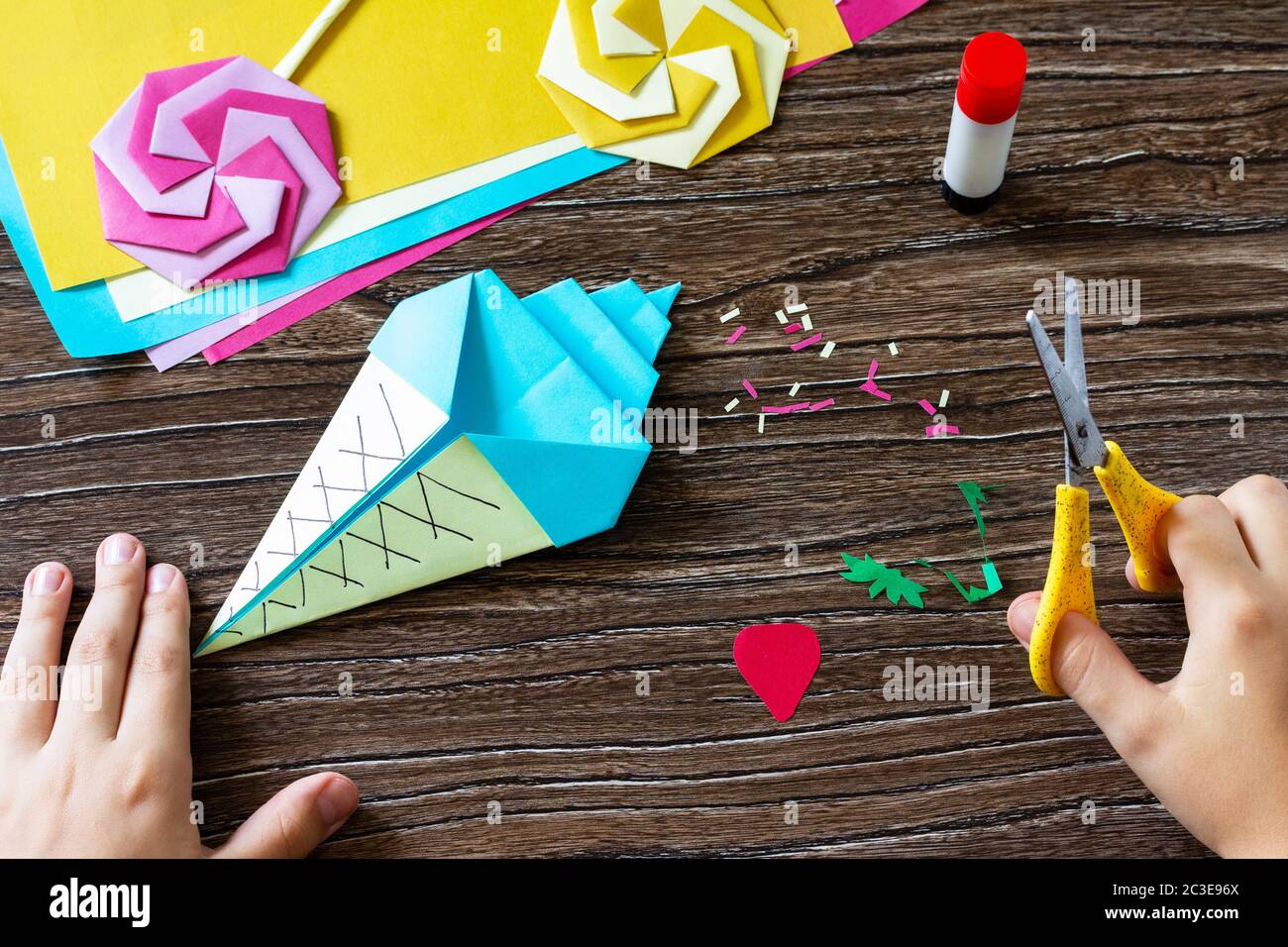 Instruction step 12. Funny toy Origami paper ice cream on a wooden table.  Children's art project, handmade, crafts for children Stock Photo - Alamy
