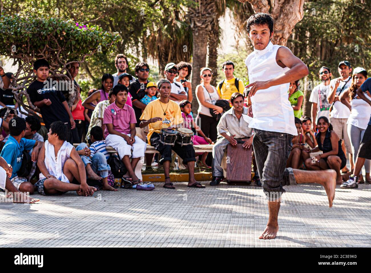 Young men dancing on the sidewalk in Huacachina. Ica, Department of Ica, Peru. Stock Photo