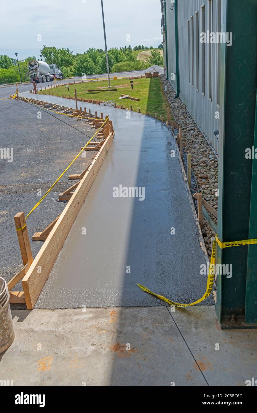 Vertical shot of a new concrete sidewalk that has just been poured with framing. Stock Photo