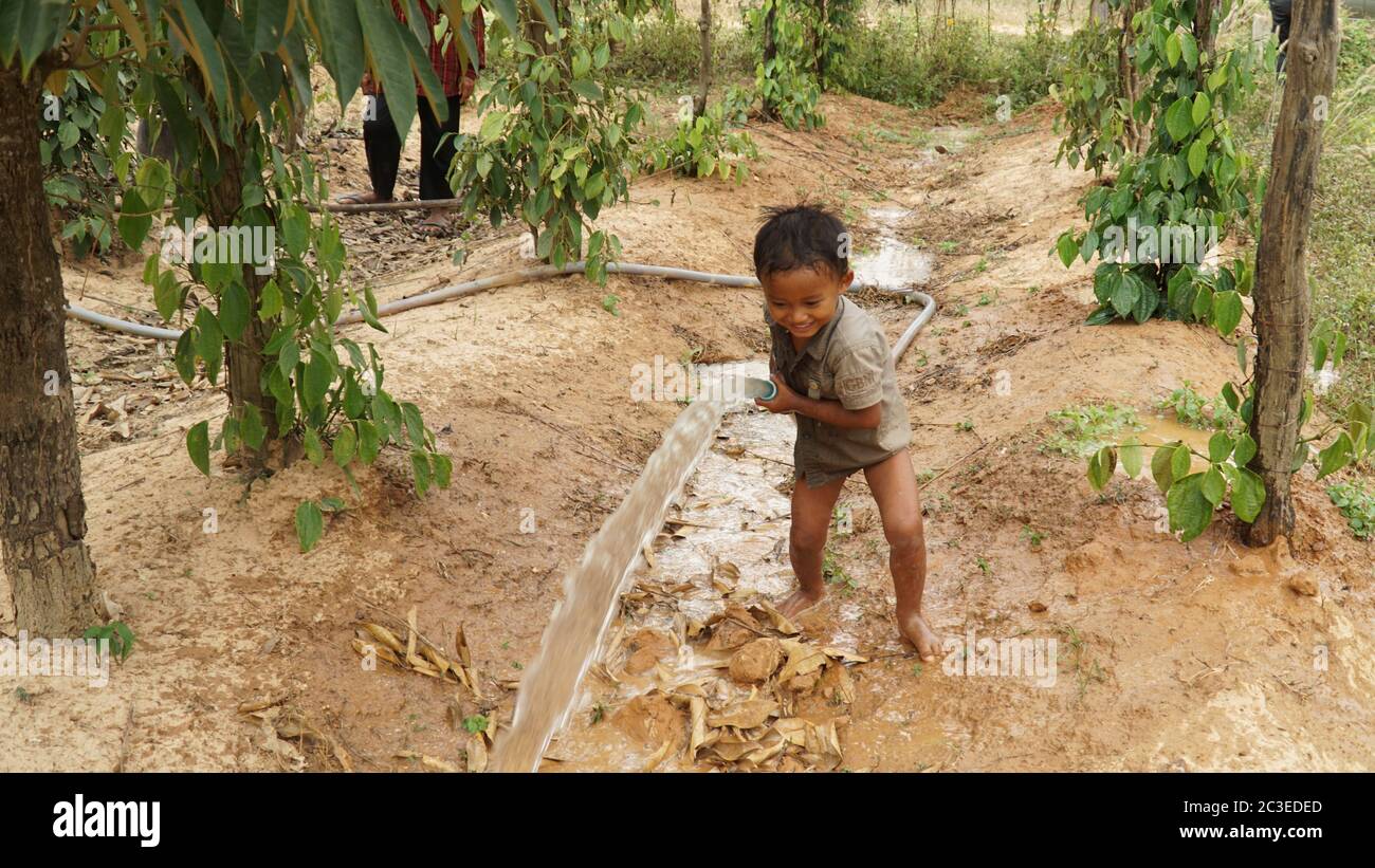 Young boy playing with water in the Sothy peper farm region of Kep in  Cambodia Stock Photo - Alamy
