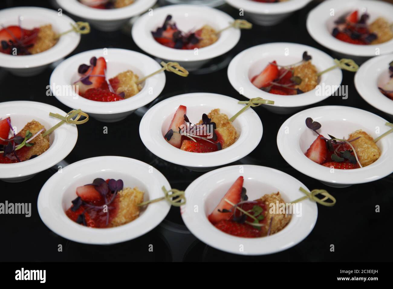 Small piece of breaded tofu with fresh strawberries in a small plate in a buffet Stock Photo
