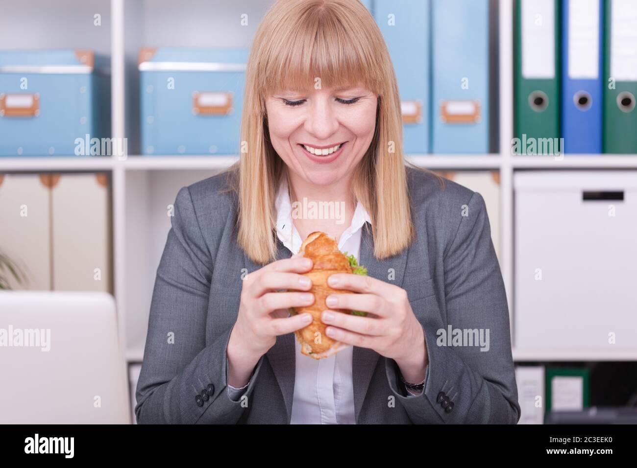 Woman at the office eating food in her break. Business, diet and healthy lifestyle concept. Stock Photo