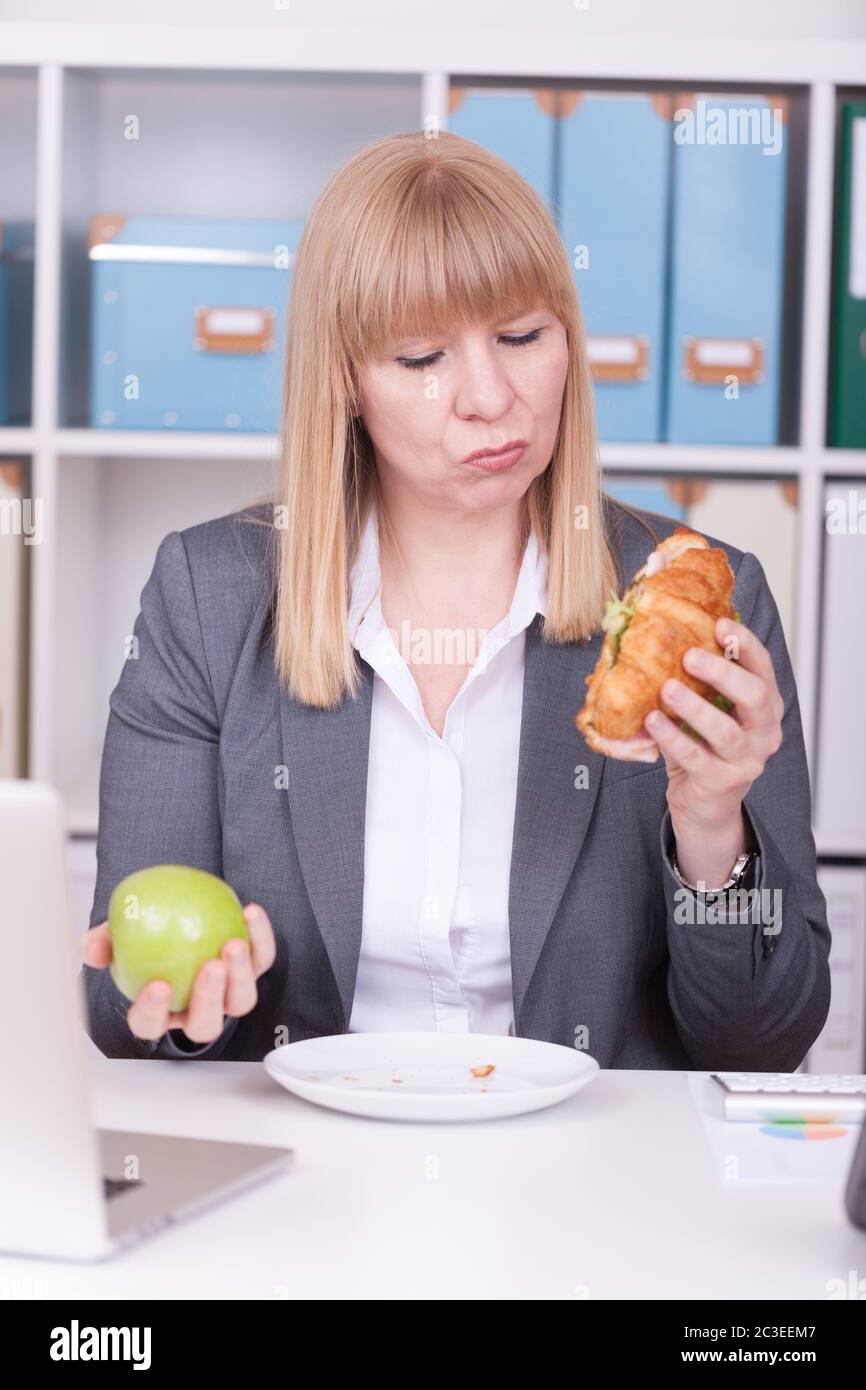Woman at the office eating food in her break. Business, diet and healthy lifestyle concept. Stock Photo
