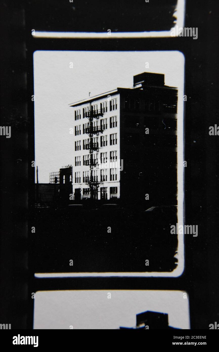 Fine 70s vintage contact print black and white extreme photography of a tall apartment building standing in the city. Stock Photo