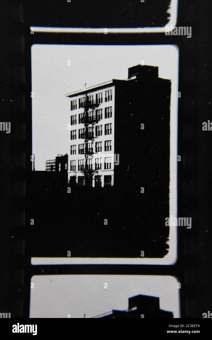 Fine 70s vintage contact print black and white extreme photography of a tall apartment building standing in the city. Stock Photo