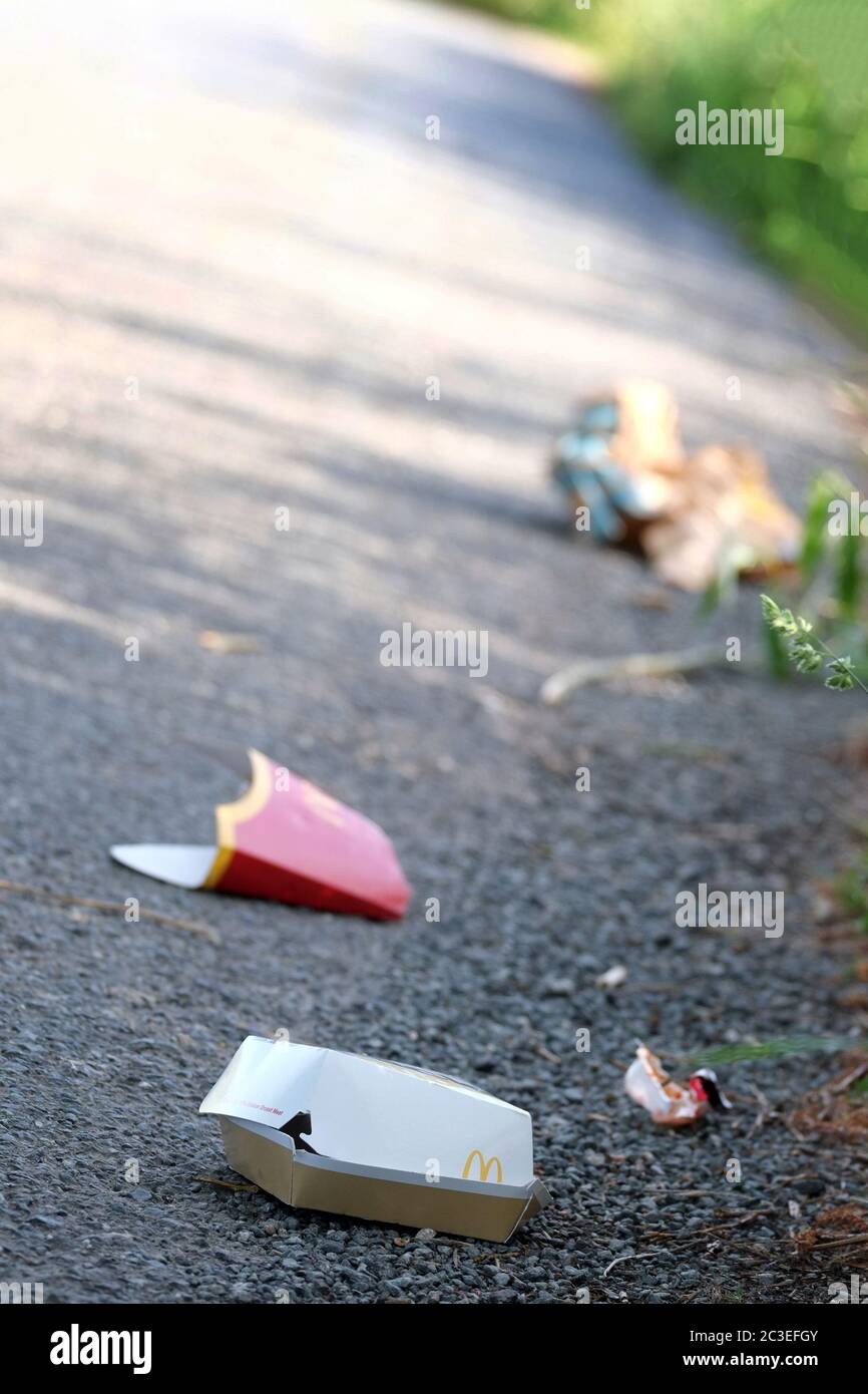 June 2020 - Fast food bags and wrappers left on the road, probably thrown from a car. Stock Photo