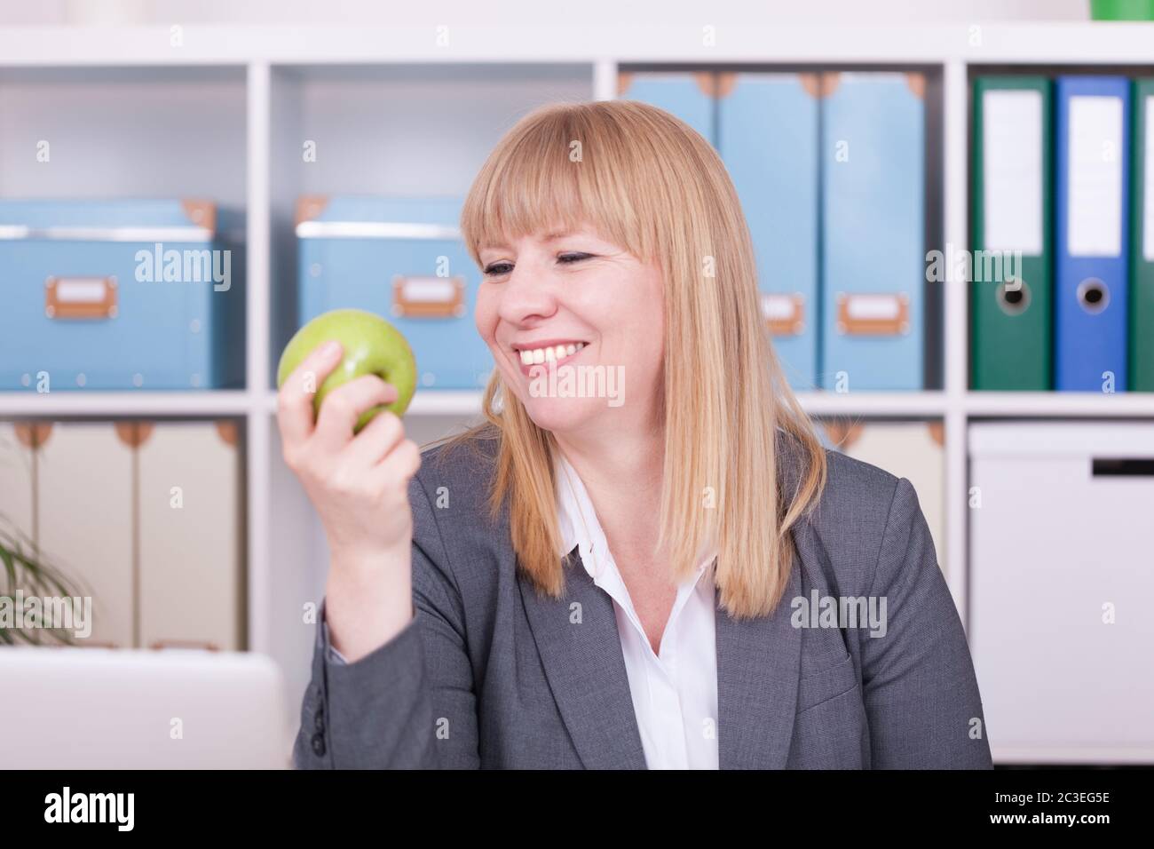 Woman at the office eating food in her break. Business, diet and healthy lifestyle concept. Stock Photo