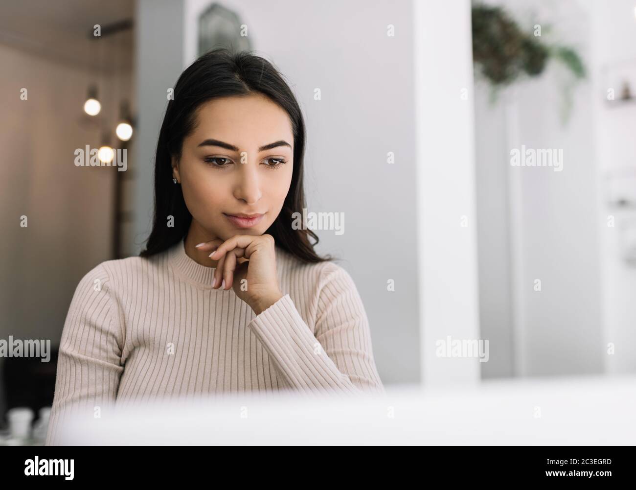 Close up portrait of pensive Indian woman using laptop, watching training courses online. Asian freelancer working from home Stock Photo