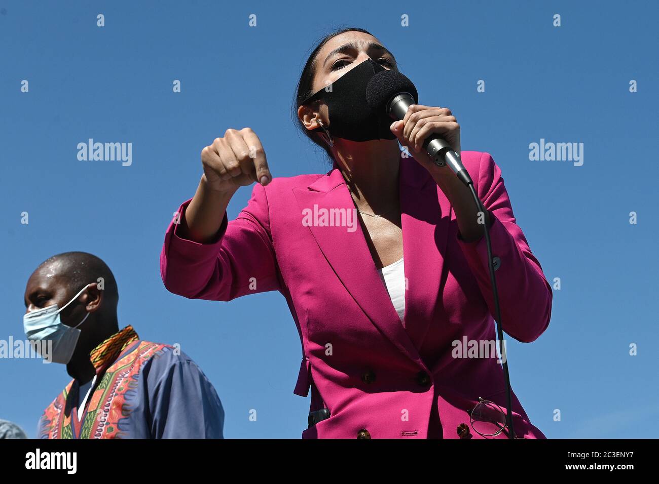 Wearing a mask in the time of COVID-19, U.S. Representative Alexandria Ocasio-Cortez (purple) speaks at a Juneteenth celebration rally in front of the Unisphere in Flushing Meadows-Corona Park in the borough of Queens, New York, June 19, 2020. Juneteenth is celebrated as a commemoration of the ending of slavery in the United States. Credit: Sipa USA/Alamy Live News Stock Photo
