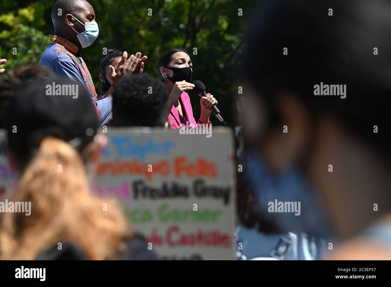 Wearing a mask in the time of COVID-19, U.S. Representative Alexandria Ocasio-Cortez (purple) speaks at a Juneteenth celebration rally in front of the Unisphere in Flushing Meadows-Corona Park in the borough of Queens, New York, June 19, 2020. Juneteenth is celebrated as a commemoration of the ending of slavery in the United States. Credit: Sipa USA/Alamy Live News Stock Photo