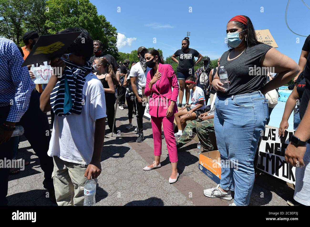 Wearing a mask in the time of COVID-19, U.S. Representative Alexandria Ocasio-Cortez (purple) reacts as rallygoer is collapses at a Juneteenth celebration rally in front of the Unisphere in Flushing Meadows-Corona Park in the borough of Queens, New York, June 19, 2020. Juneteenth is celebrated as a commemoration of the ending of slavery in the United States.  The announcement came two year after President Abraham Lincoln's Credit: Sipa USA/Alamy Live News Stock Photo