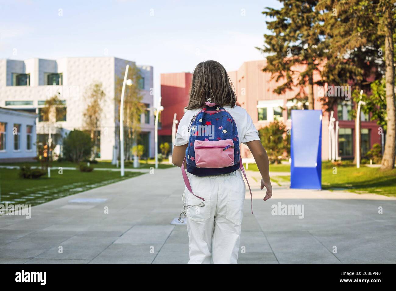 Girl with backpack walking to school Stock Photo