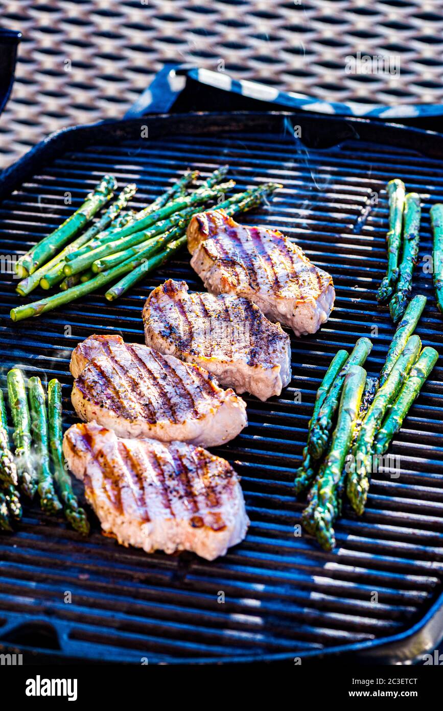 Pork chops and asparagus on grill Stock Photo