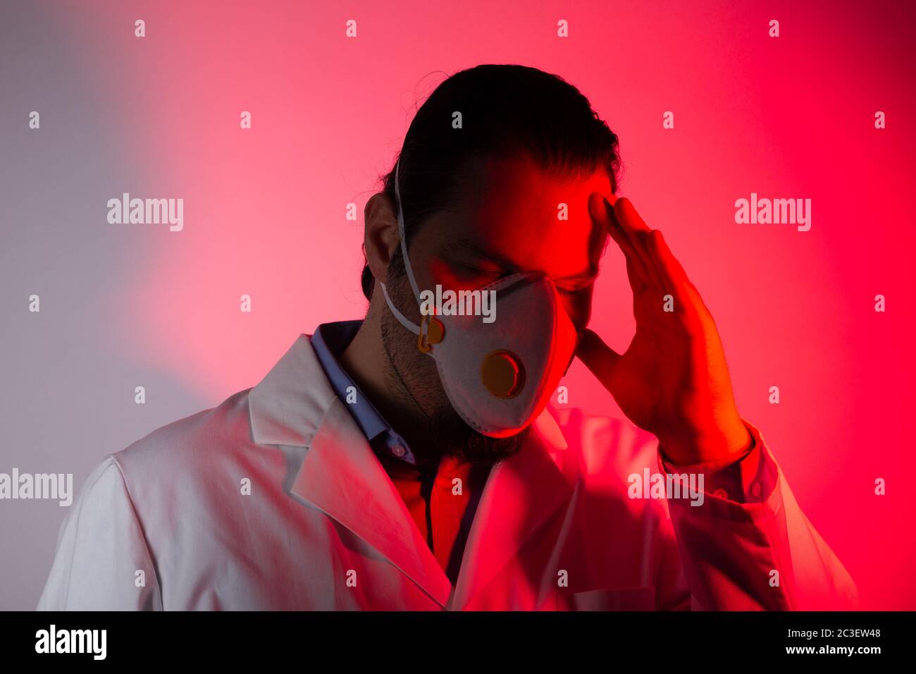 Medical doctor wearing a respiratory mask. Red light emergency and medicine crisis concept. Stock Photo