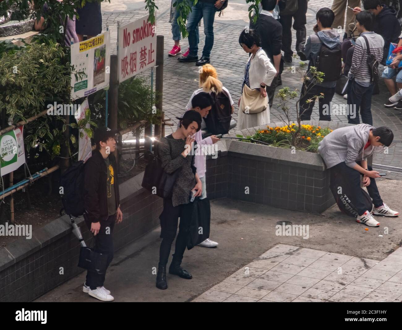 Smokers smoking at a designated area in Shibuya, Tokyo, Japan Stock Photo