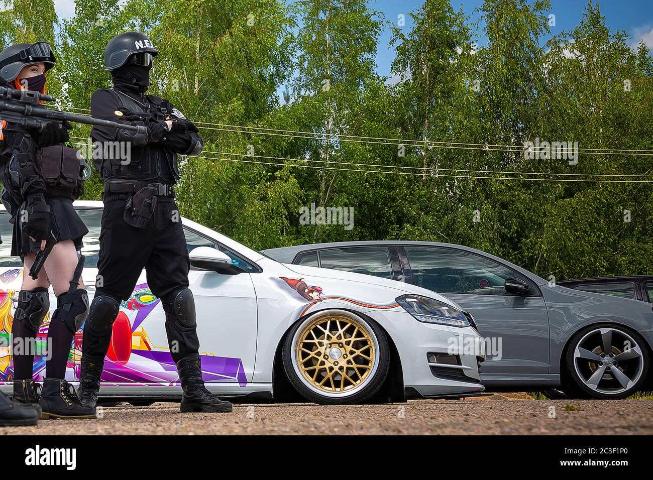 Moscow, Russia: July 06, 2019: Cosplay soldiers on guard tuned with low suspension, gray Volkswagen Golf 6 and White Golf 7 are in the parking lot on the background of the forest. Stock Photo