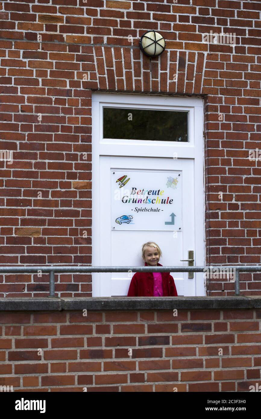 Girl (7) in front of the school daycare center, Kiel, Schleswig-Holstein, Germany Stock Photo