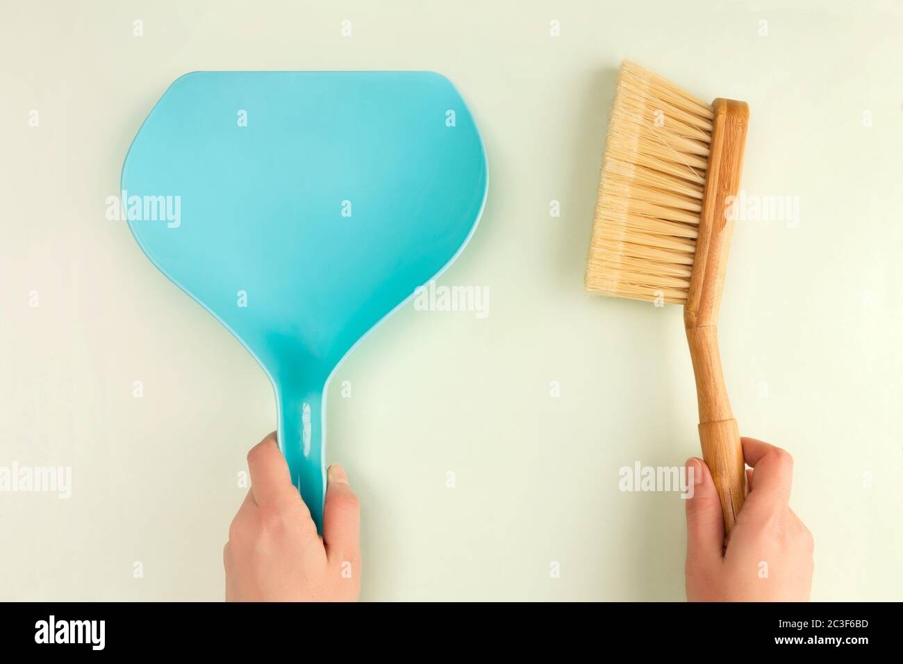 Plastic scoops and wooden brush in woman hands. Stock Photo