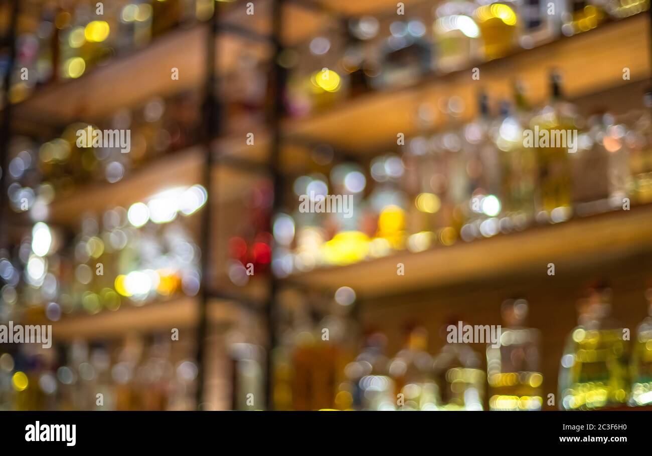 Defocused background of bar counter with various bottles of alcohol. Stock Photo