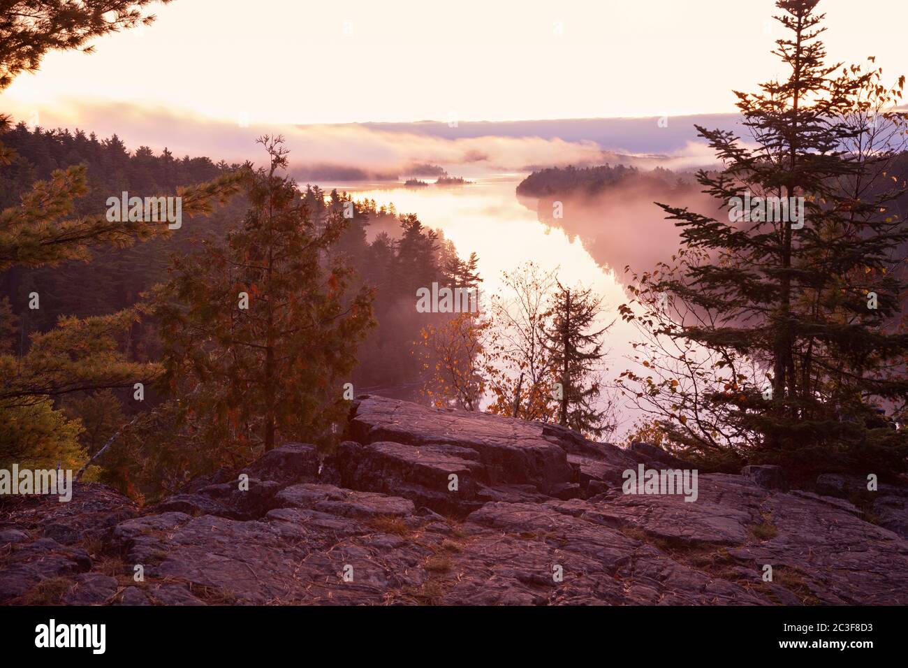 Northern Minnesota lake viewed from a rocky cliff at dawn during autumn Stock Photo
