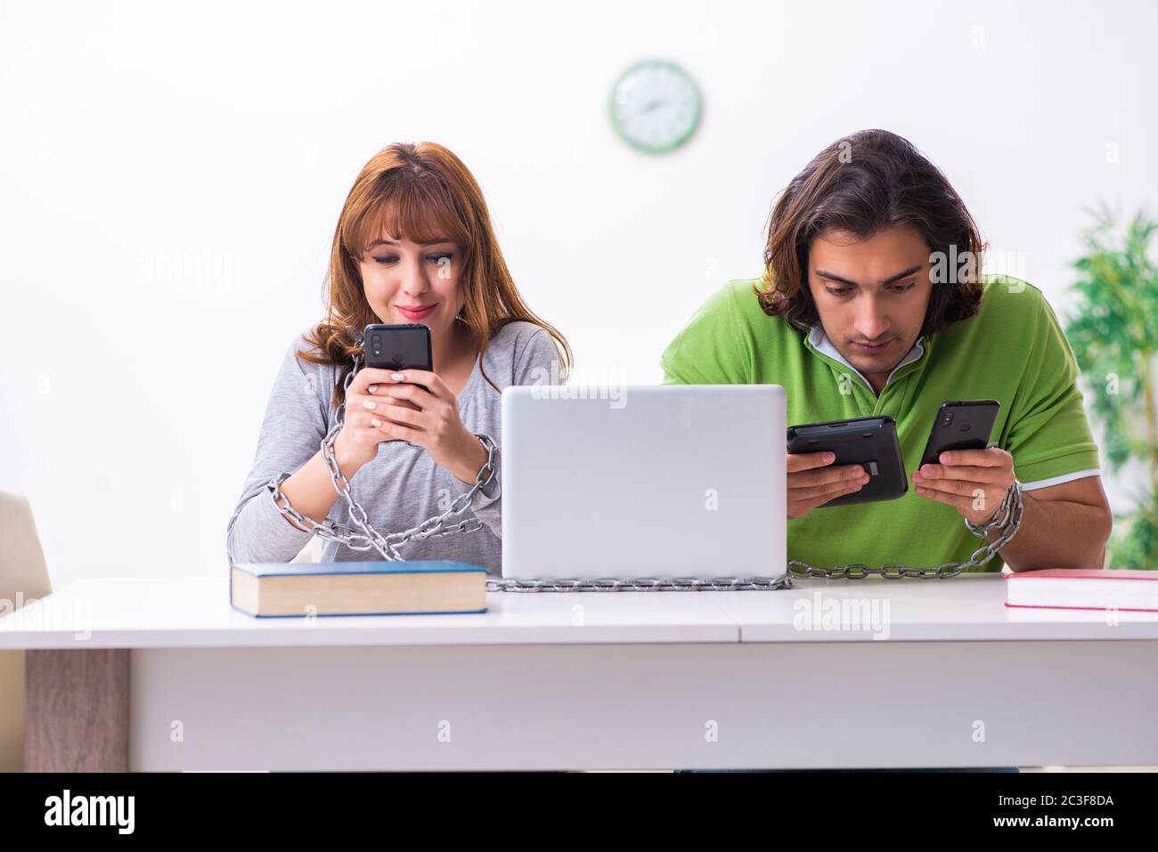 Two students in gadget dependency concept Stock Photo