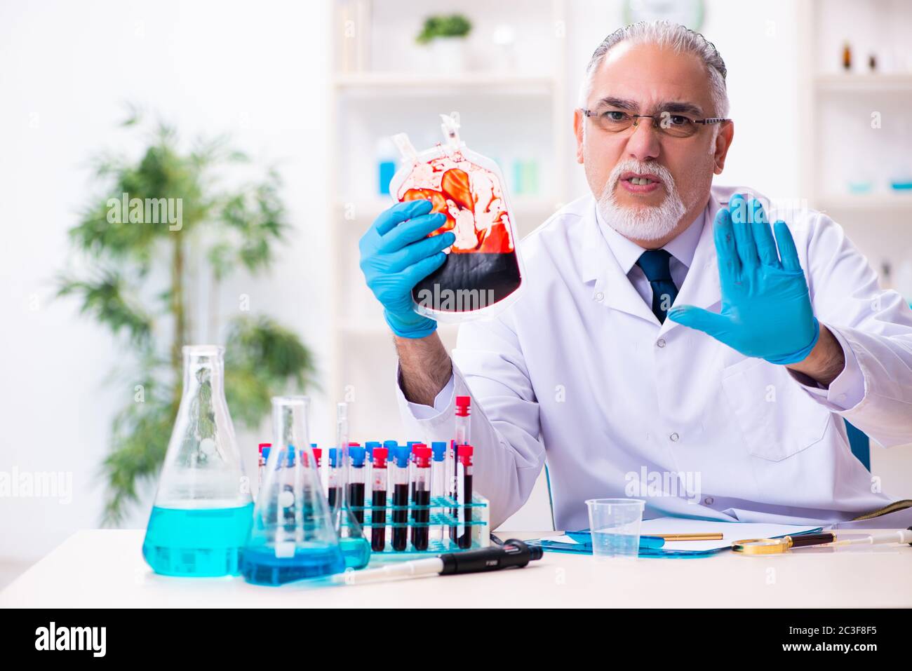 Old male chemist working in the lab Stock Photo