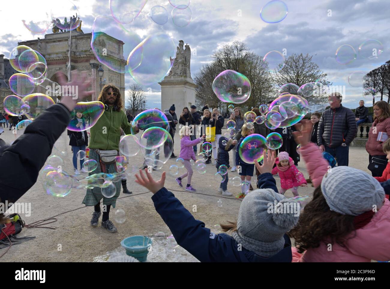 Children enjoying entertainment with life size soap bubbles, Paris FR