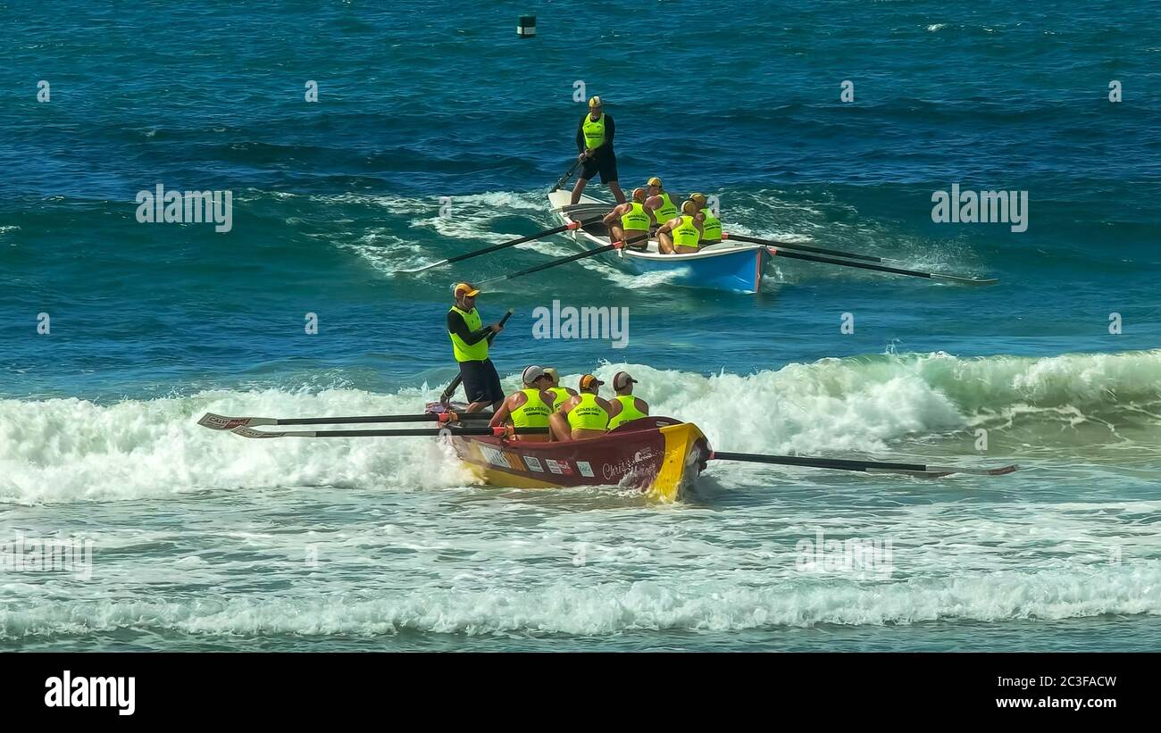 ALEXANDRA HEADLAND, QUEENSLAND, AUSTRALIA- APRIL 22, 2016: two surf boats catching waves at the end of a race Stock Photo