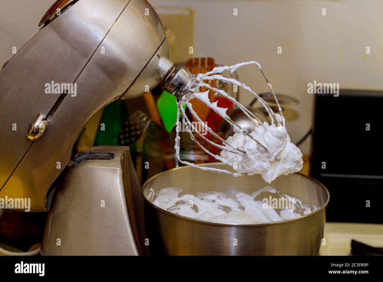 Stable whipped egg whites on whisk of stand electric mixer Stock Photo